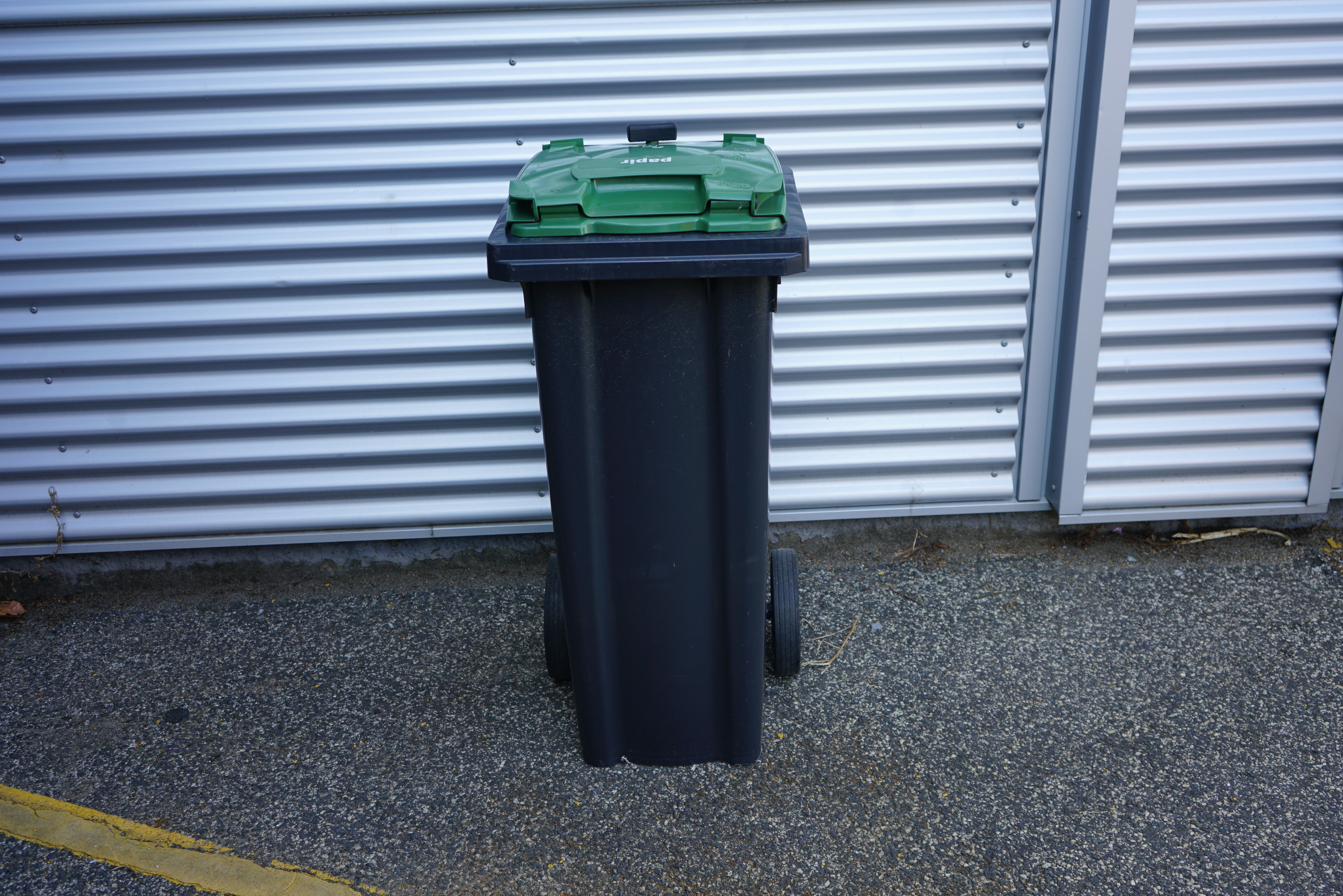 Grøn affaldscontainer 140 liter med hjul set forfra – robust udendørs skraldespand til affaldssortering